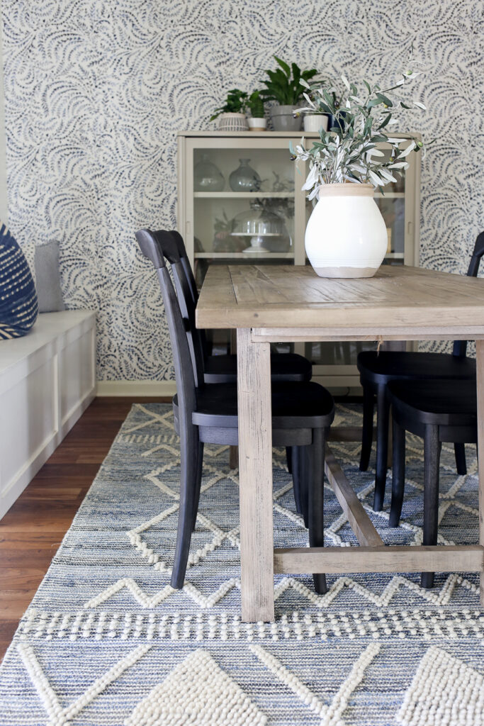Coastal Dining Room with gray washed Pottery Barn dining table, black bistro chairs with a close look at the blue and white textured rug