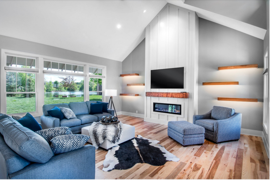 Wood accent fireplace with a tv mounted over it and floating shelves on both sides of the fireplace.