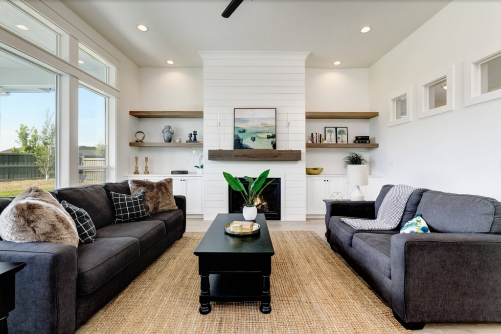 Bright white shiplap fireplace with chunky wood mantle and chunky wood floating shelves flanking the fireplace.