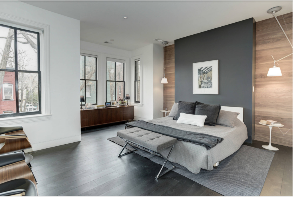Light gray accent wall with wood accents in a small master bedroom.