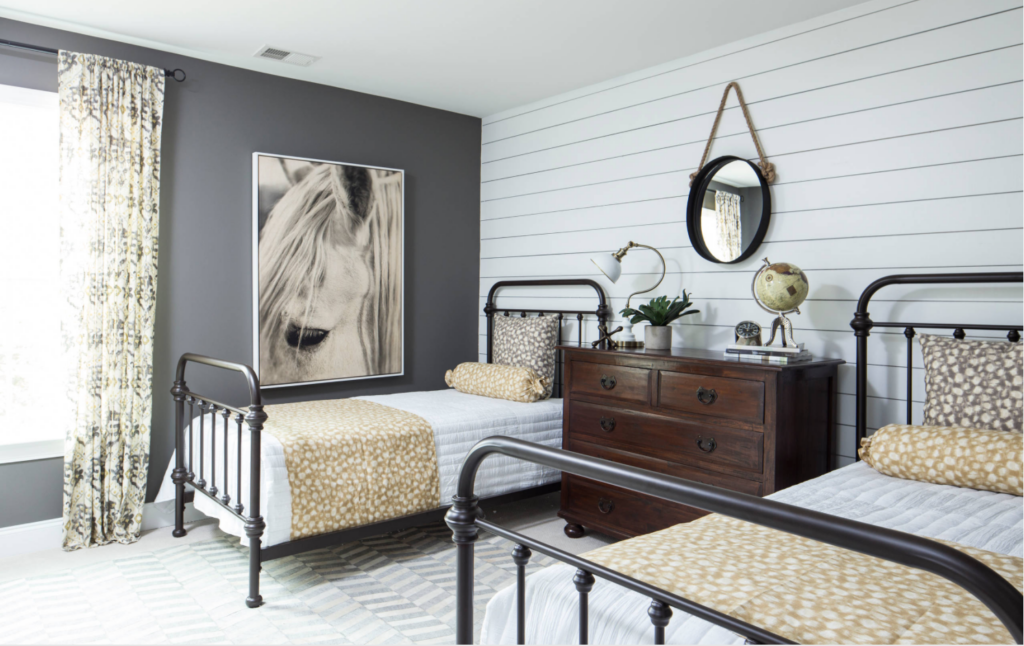 SHiplap accent wall in a room with two beds and wall to wall carpeting.