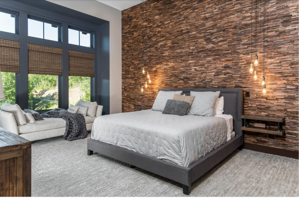 Stacked stones used in a room to accent a wall behind a bed.
