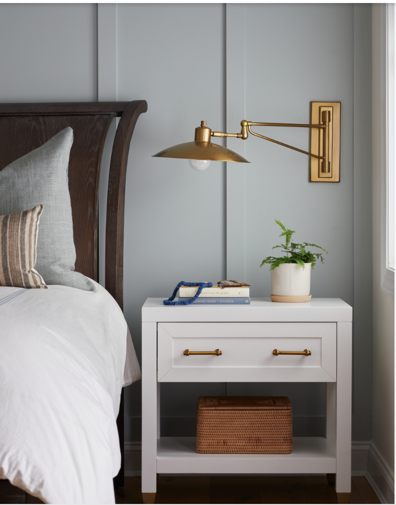 Gray wood trim accent wall in a room with a large wooden headboard and white side boards.