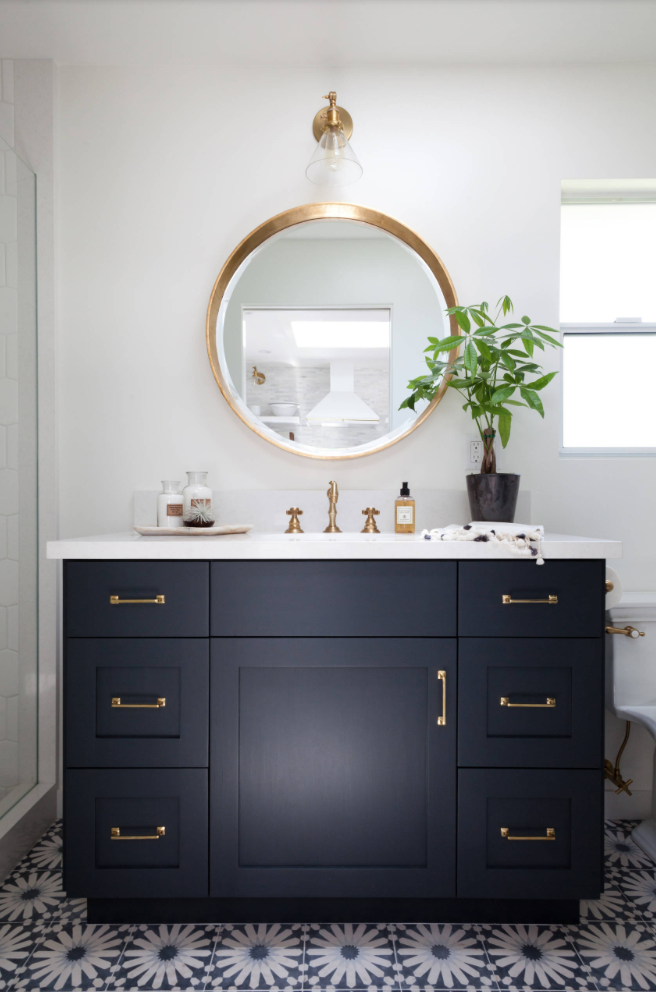 Bathroom cabinet painted using a black paint color in a bright bathroom.