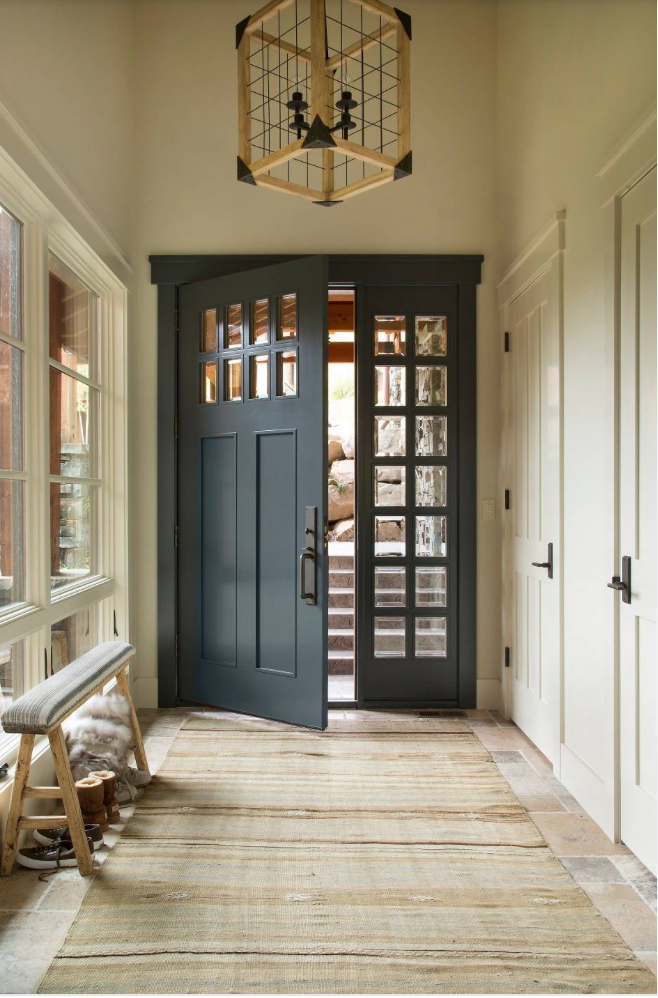 Benjamin Moore midnight blue in an entryway with neutral accent pieces and a large wooden light fixture.