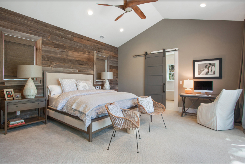 Kendall Charcoal painted barn door leading to a bathroom within a bedroom.