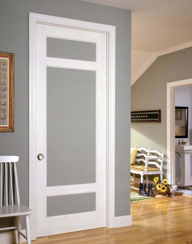 Gray and white painted interior door in a space wioth light wooden flooring and gray coordinating walls.