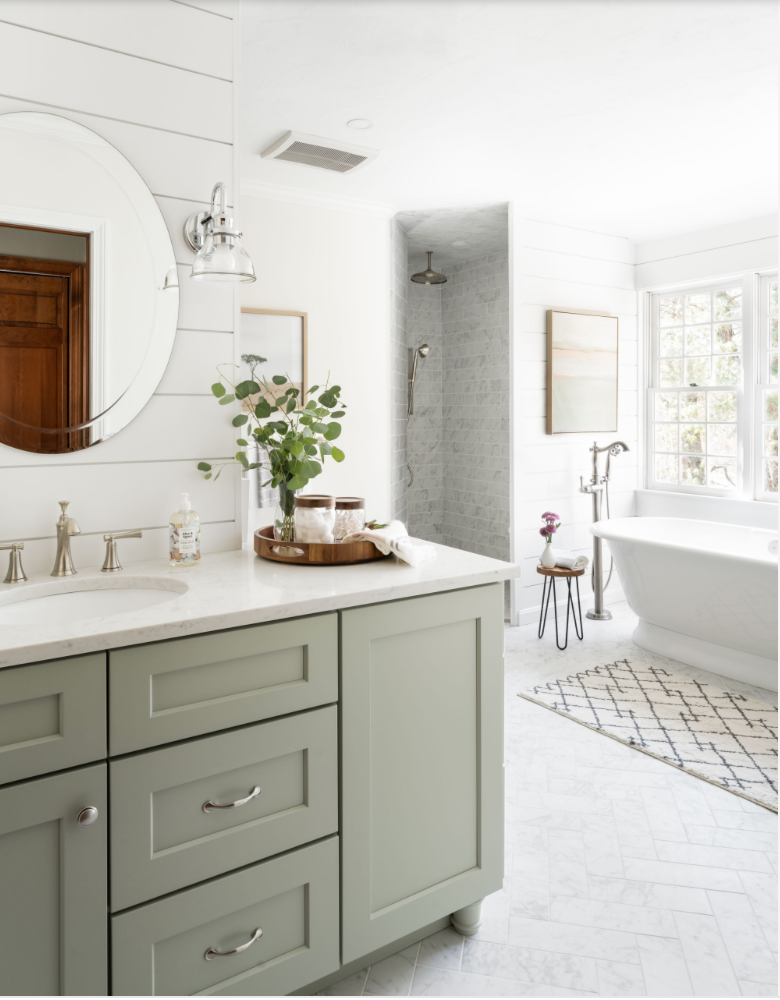 Bathroom cabinet painted in sage green in a large and open bathroom.